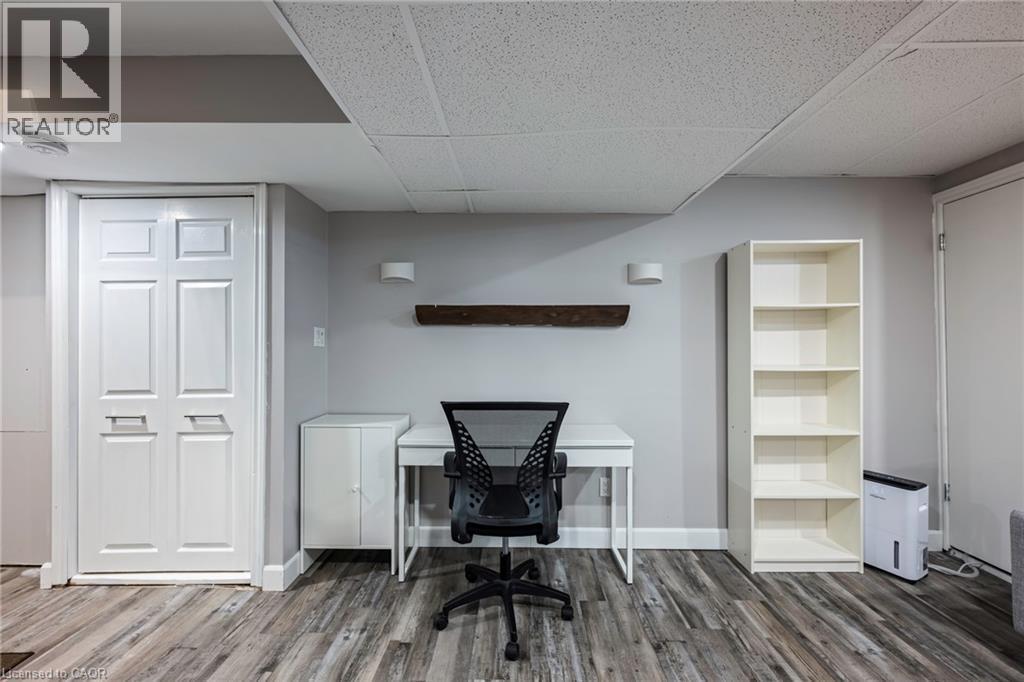 Wood-finish flooring with light gray walls, a ceiling tile finish, and white bi-fold doors - 364 Stoneheight Place, Waterloo, ON
