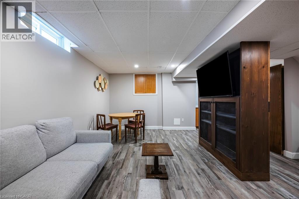 Wood-finish flooring with recessed lighting, a built-in media cabinet, and a transom window - 364 Stoneheight Place, Waterloo, ON