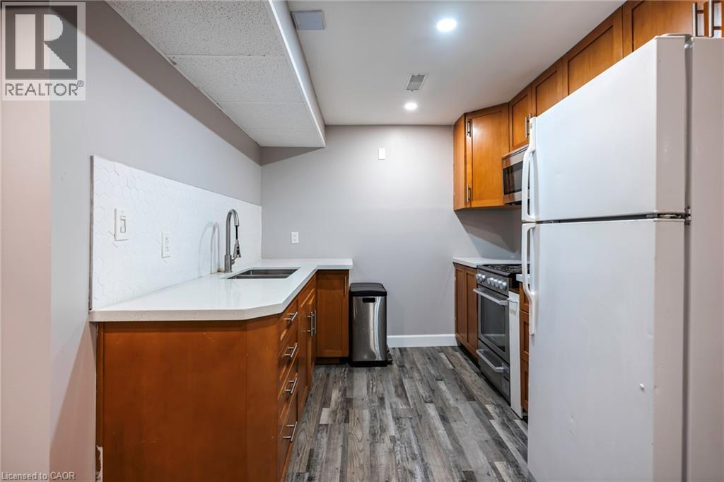 Wood-finish flooring, white countertops, stainless steel appliances, and wood cabinetry - 364 Stoneheight Place, Waterloo, ON