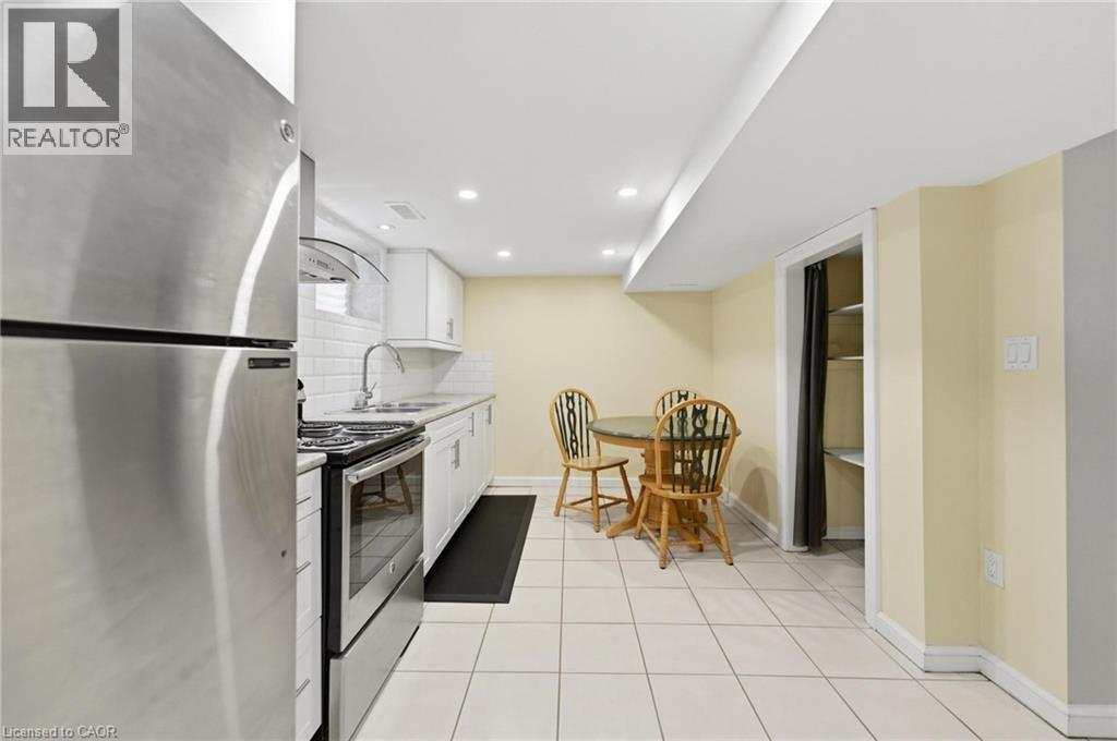 Kitchen featuring stainless steel appliances, white subway tile backsplash, white cabinetry, and recessed lighting - 69 Nash Road S, Hamilton, ON