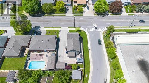 Expansive backyard featuring an in-ground swimming pool, a multi-level wood deck, and a paved patio area - 69 Nash Road S, Hamilton, ON 