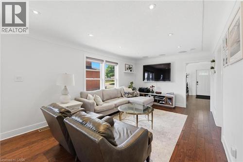 Bright living area featuring wood-finish flooring, recessed lighting, and white baseboards - 69 Nash Road S, Hamilton, ON 