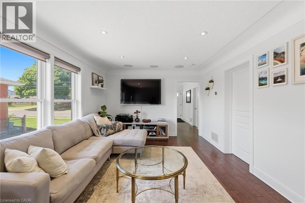 Bright living area featuring wood-finish flooring and recessed lighting - 69 Nash Road S, Hamilton, ON