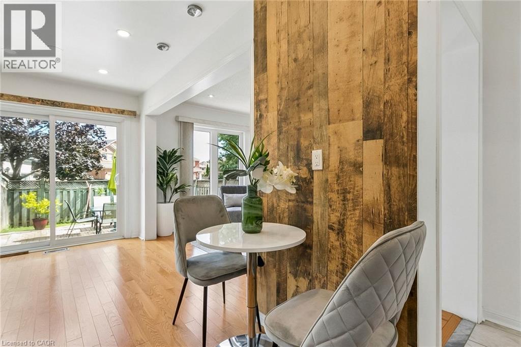 Hardwood flooring, recessed lighting, sliding glass door, and a distressed wood-paneled feature wall - 1373 Quest Circle, Mississauga, ON