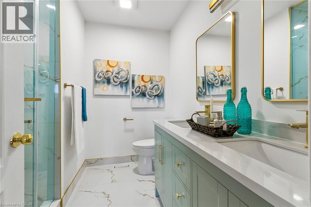 Dual vanity with integrated sinks, light-toned countertop, and gold-finish fixtures - 1373 Quest Circle, Mississauga, ON