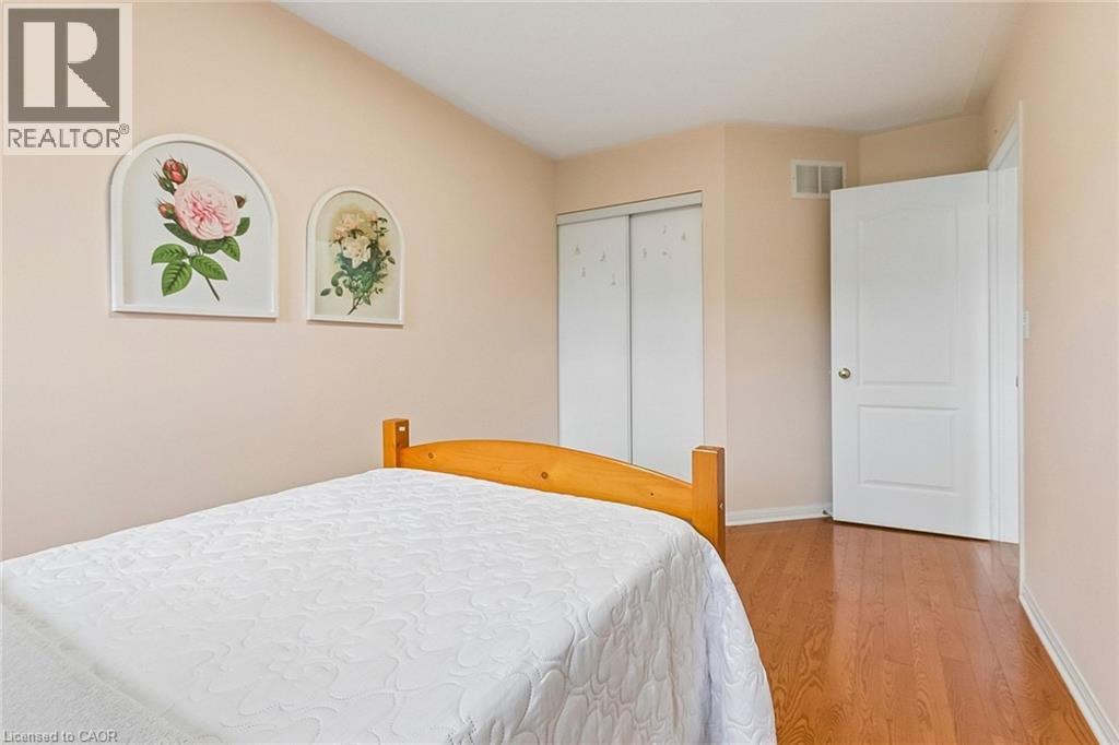 Wood-finish flooring, white sliding closet doors, and a white interior door - 1373 Quest Circle, Mississauga, ON