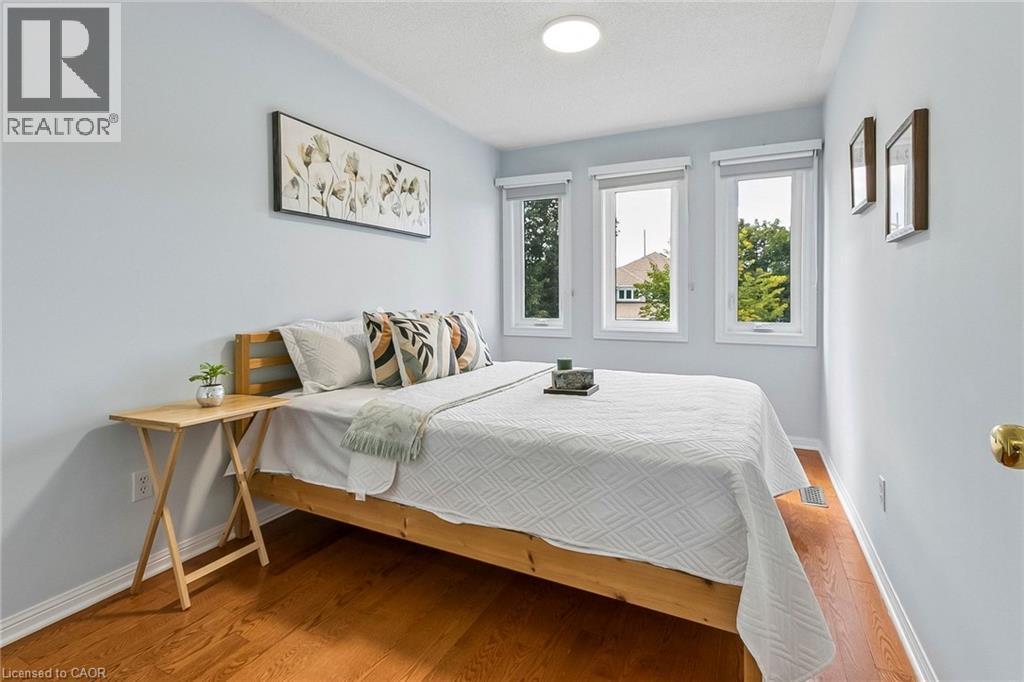 Light wood-finish flooring, three windows with roller shades, recessed ceiling light fixture, and light-toned wall paint - 1373 Quest Circle, Mississauga, ON