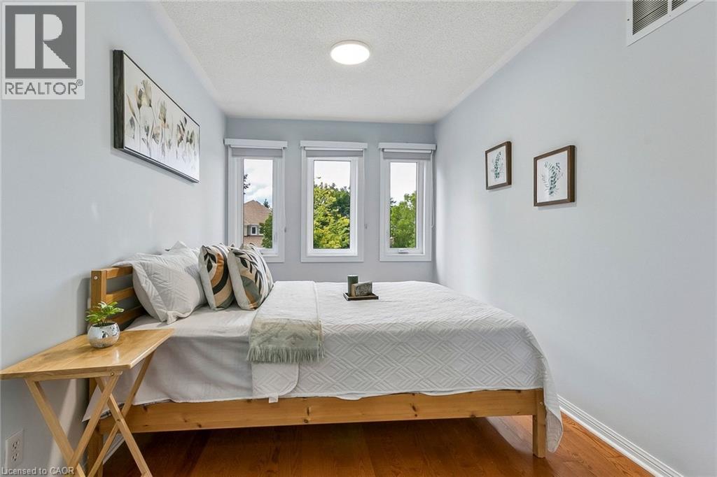 Warm wood-finish flooring, three paneled windows, and a ceiling-mounted light fixture - 1373 Quest Circle, Mississauga, ON