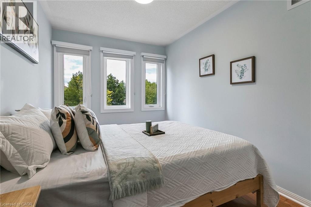 Multiple windows with roller shades, light-toned walls, and wood-finish flooring - 1373 Quest Circle, Mississauga, ON