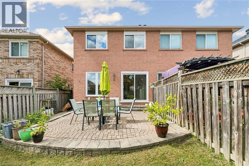 Brick exterior with multiple windows, sliding glass door, and paver patio - 1373 Quest Circle, Mississauga, ON