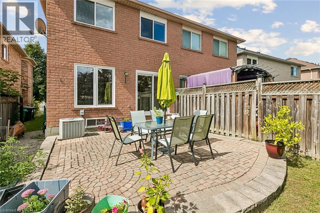 Brick exterior featuring multiple windows and a sliding glass door - 1373 Quest Circle, Mississauga, ON