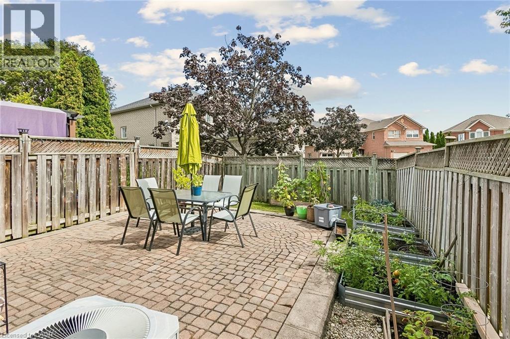 Brick paver patio, wood fencing, mature trees, and raised garden beds - 1373 Quest Circle, Mississauga, ON