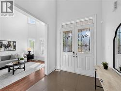 Double entry doors with decorative glass panels, transom window, and tiled flooring -