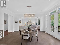 Spacious dining area featuring stone tile flooring, recessed lighting, crown molding, a linear chandelier, and French doors leading to an outdoor space -