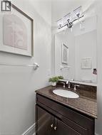 Dark wood-finish vanity with an undermount oval sink, chrome faucet, and speckled countertop -