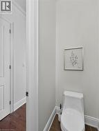 White toilet with a dual-flush mechanism and a brown tile floor -