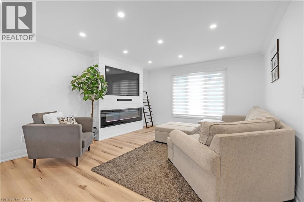 Recessed lighting, wood-finish flooring, built-in fireplace, and horizontal window blinds - 4236 Longmoor Drive, Burlington, ON