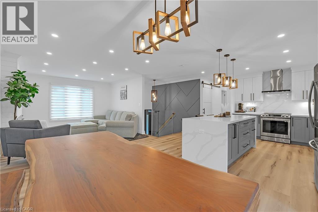 Open-concept living space with recessed lighting, wood-finish flooring, and a modern kitchen - 4236 Longmoor Drive, Burlington, ON