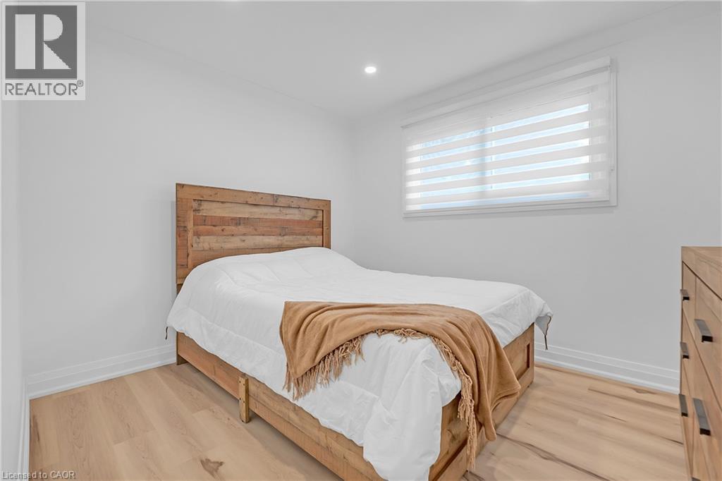 Recessed ceiling lighting, a large window with horizontal blinds, and wood-finish flooring - 4236 Longmoor Drive, Burlington, ON