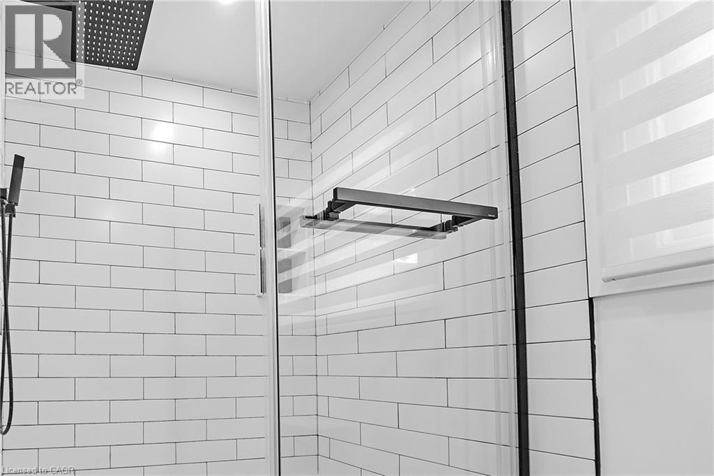 Shower with subway tile, glass enclosure, square rainfall showerhead, and handheld shower sprayer - 4236 Longmoor Drive, Burlington, ON