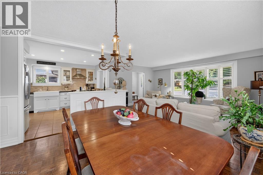 Hardwood-finish flooring, recessed lighting, and a chandelier illuminate the dining space - 1434 Dewbourne Crescent, Burlington, ON