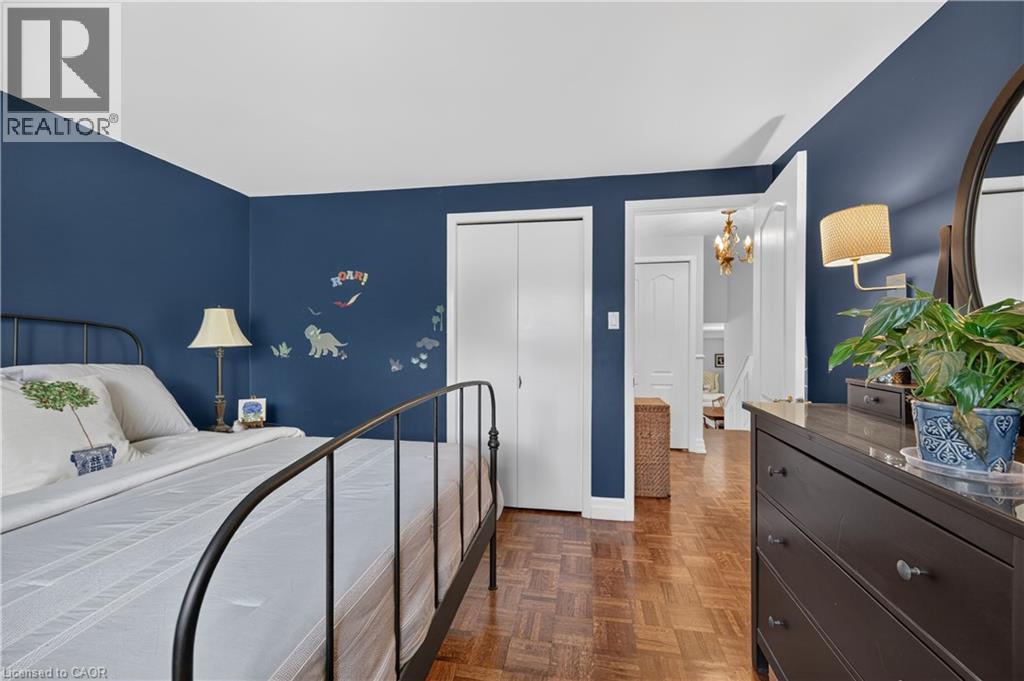 Parquet wood-finish flooring, white bi-fold closet doors, and a wall-mounted light fixture - 1434 Dewbourne Crescent, Burlington, ON