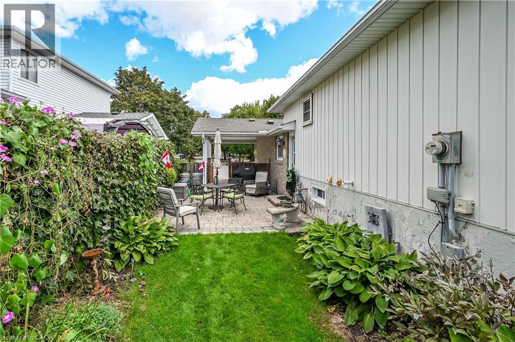 Manicured lawn with a paver patio and covered outdoor structure - 1434 Dewbourne Crescent, Burlington, ON
