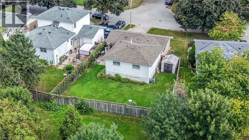 Expansive backyard featuring a manicured lawn, established perimeter fencing, and mature trees - 1434 Dewbourne Crescent, Burlington, ON