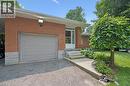 Brick facade residence featuring a single-cargarage with a panel door and large LED exteriorlighting - 410 Avenue Road, Cambridge, ON 