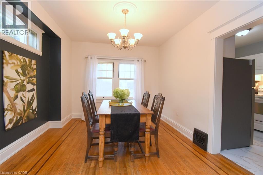 Wood-finish flooring with accent inlay, transom window, and a built-in light fixture with decorative ceiling medallion - 35 Tisdale Street S, Hamilton, ON