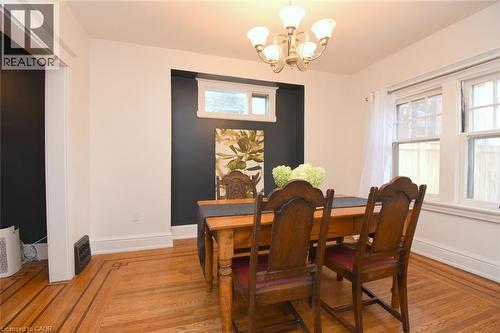 Hardwood flooring with border inlay, white trim, recessed wall feature with window, and a chandelier - 35 Tisdale Street S, Hamilton, ON 