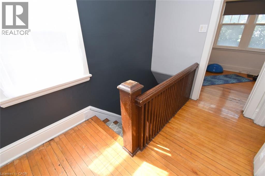 Hardwood flooring, painted walls, white trim, and a wood railing - 35 Tisdale Street S, Hamilton, ON