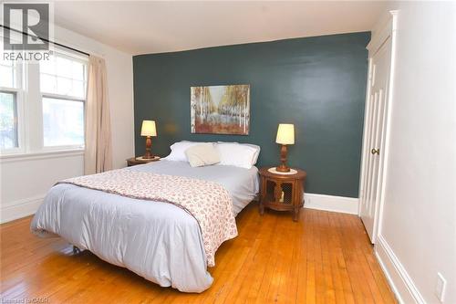 Hardwood flooring, painted accent wall, windows with trim, and a built-in closet with panel detailing - 35 Tisdale Street S, Hamilton, ON 