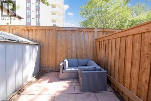 Private outdoor space featuring wood fencing and a paved patio area - 35 Tisdale Street S, Hamilton, ON 