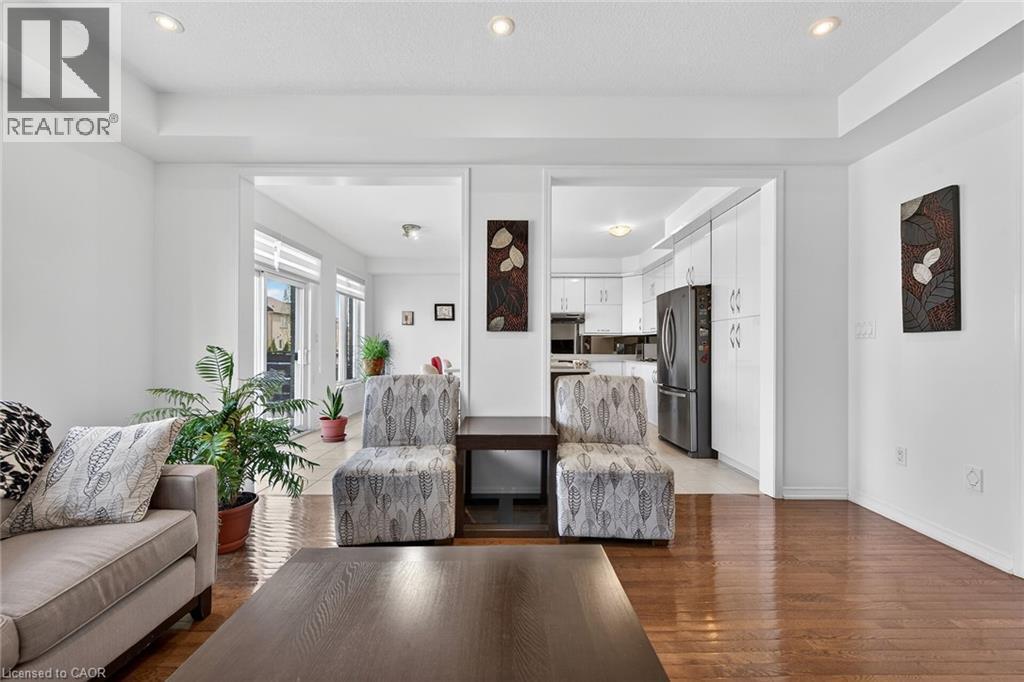 Living area with light wood-type flooring, recessed lighting, and a raised ceiling - 97 Sirente Drive, Hamilton, ON