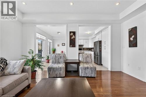 Living area with light wood-type flooring, recessed lighting, and a raised ceiling - 97 Sirente Drive, Hamilton, ON 