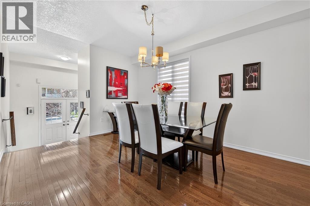 Dining room with dark wood-style floors, hanging lights, and a textured ceiling - 97 Sirente Drive, Hamilton, ON