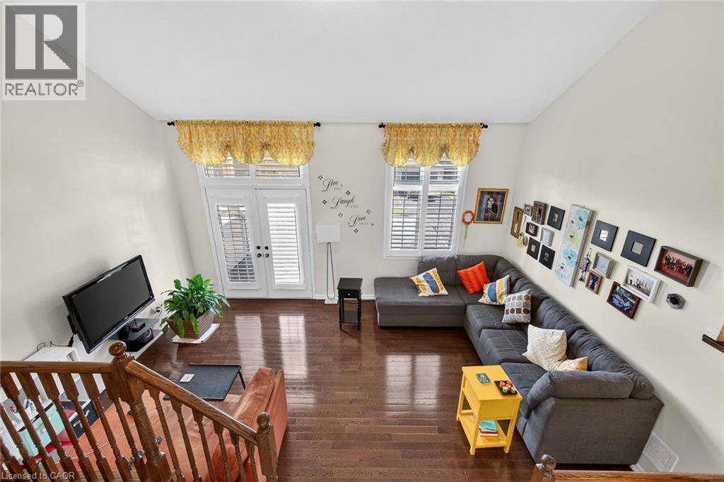 Living area featuring dark wood-style floors and french doors - 97 Sirente Drive, Hamilton, ON