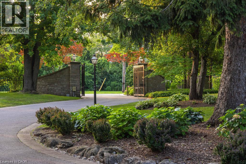 Stone entry pillars with integrated lighting and wrought iron gates - 4038 Lakeshore Road, Burlington, ON