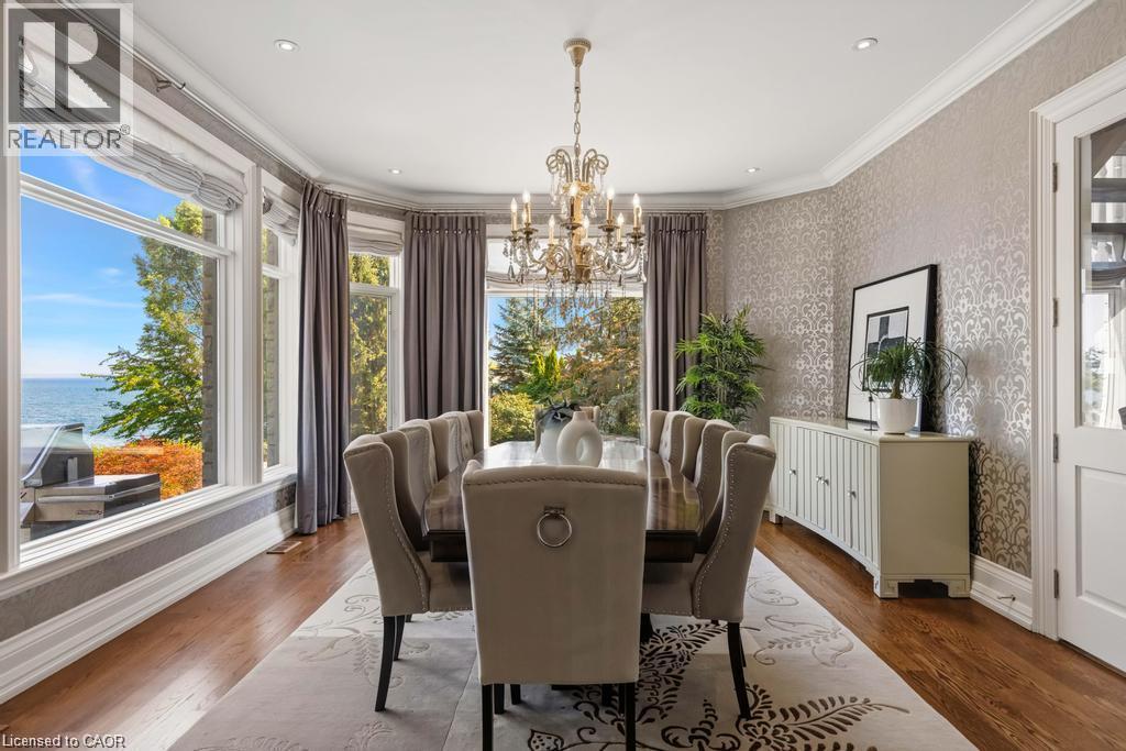 Hardwood flooring with a patterned area rug, a chandelier, recessed lighting, and expansive windows - 4038 Lakeshore Road, Burlington, ON