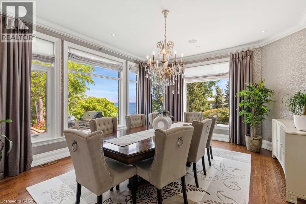 Hardwood flooring, ornate chandelier, wallpapered accent wall, recessed lighting, and large picture windows - 4038 Lakeshore Road, Burlington, ON