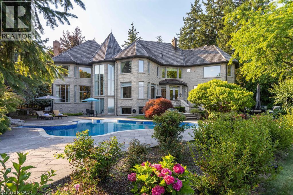Stone exterior with multiple dormers and a turretted roofline - 4038 Lakeshore Road, Burlington, ON