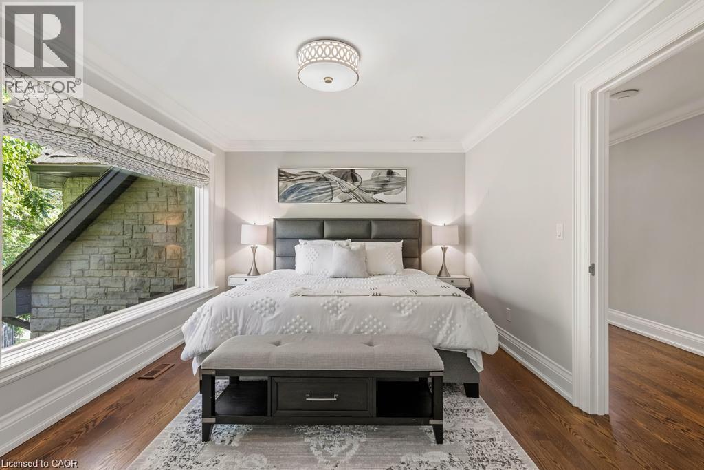 Expansive window providing ample natural light, crown molding detailing, recessed ceiling light fixture, wood-finish flooring, and a neutral wall palette - 4038 Lakeshore Road, Burlington, ON