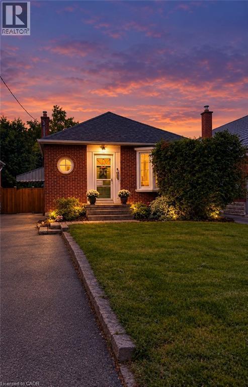 Brick exterior with a dark shingle roof and a prominent chimney - 107 Norwood Road, Hamilton, ON