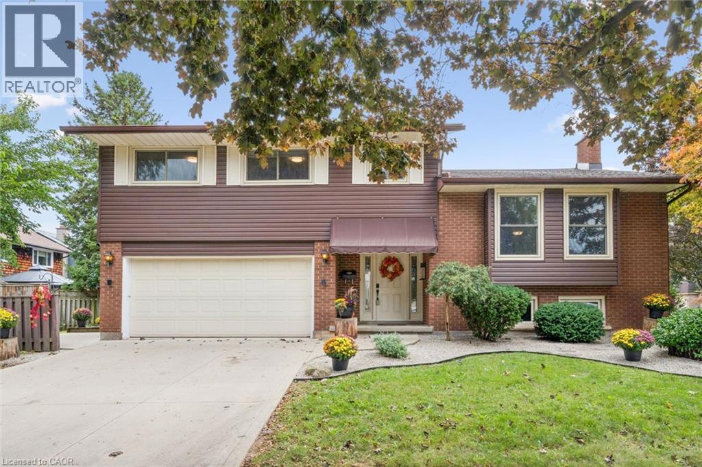 Brick and siding exterior with a pitched roof, attached two-car garage, and concrete driveway - 21 Colebrook Court, Kitchener, ON
