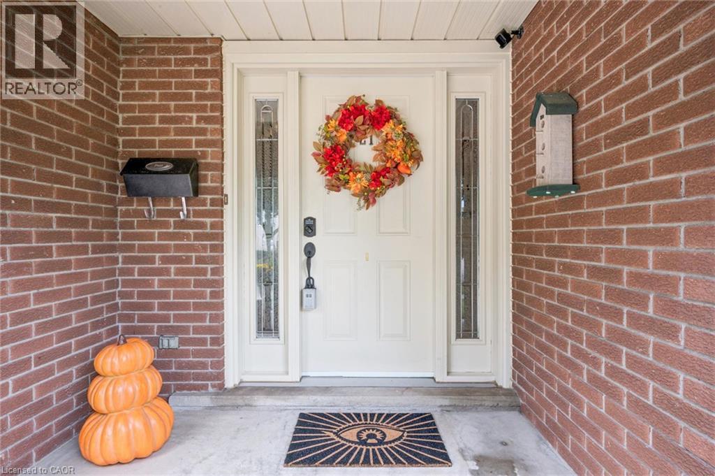Brick exterior with a white entry door, side lites, and a black mailbox - 21 Colebrook Court, Kitchener, ON