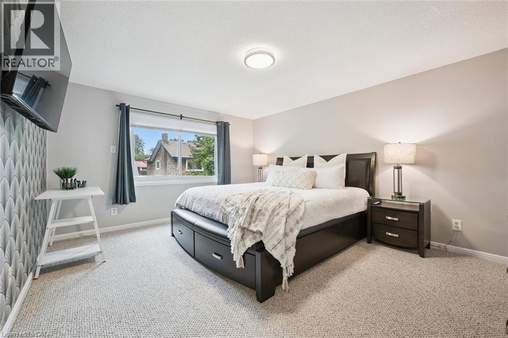 Carpeted flooring, recessed ceiling lighting, a window with roller shade, and an accent wall featuring patterned wallpaper - 21 Colebrook Court, Kitchener, ON