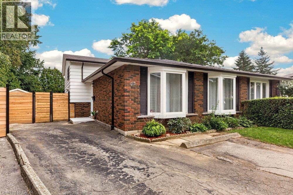 Brick and siding exterior with multiple bay windows, established landscaping, and a wood-paneled fence - 27 Gretna Court, Hamilton, ON