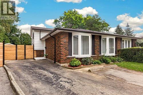 Brick and siding exterior with multiple bay windows, established landscaping, and a wood-paneled fence - 27 Gretna Court, Hamilton, ON 