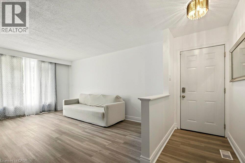 Wood-finish flooring, white walls, and a paneled entry door - 27 Gretna Court, Hamilton, ON